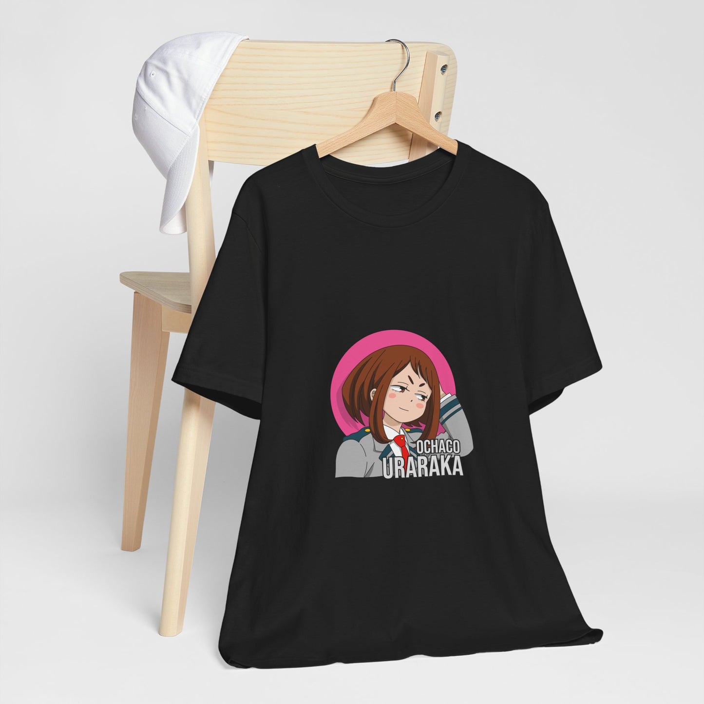 Alt: Gravity Hero Academy Anime Shirt on black, hanging on chair with cap, lifestyle display by Snapping Turtle Gallery