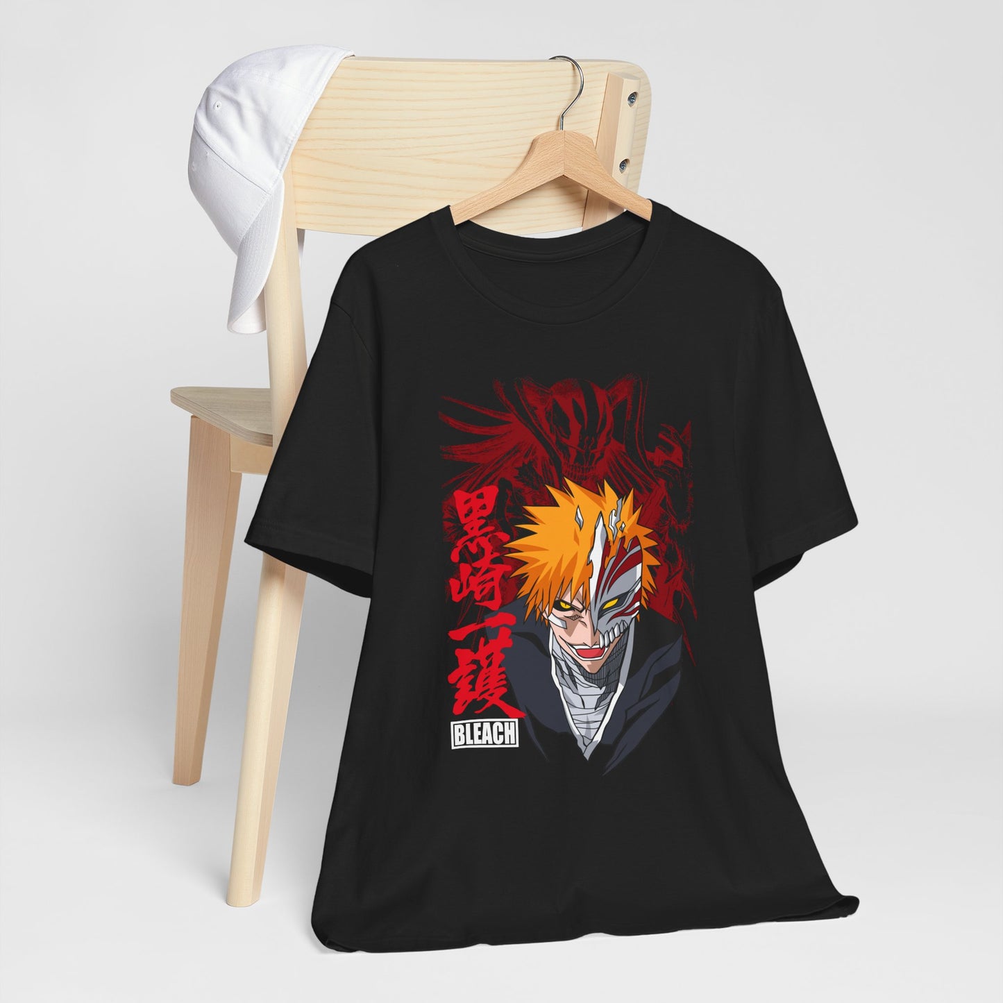 Alt: Hollow Mask Hero Anime Shirt on black, hanging on chair with cap, lifestyle display by Snapping Turtle Gallery