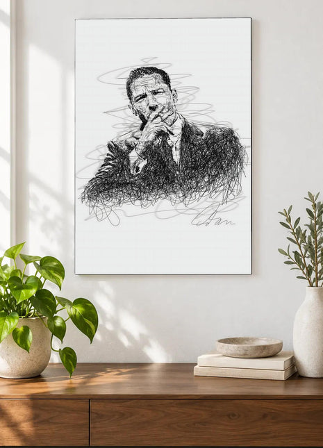 A Pause in Black Ink acrylic wall art displayed above a wooden console with plants and books against a white wall.