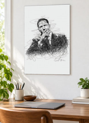 A Pause in Black Ink acrylic wall art displayed above a wooden desk with a laptop, plants and books against a white wall.