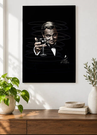 A Toast in the Dark acrylic wall art displayed above a wooden console with plants and books against a white wall.