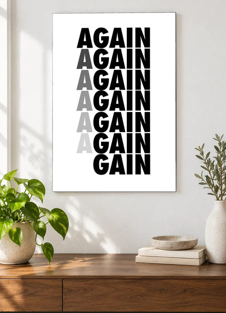Again Becomes Gain acrylic wall art displayed above a wooden console with plants and books against a white wall.