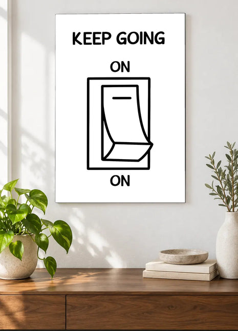 Always Switched On acrylic wall art displayed above a wooden console with plants and books against a white wall.