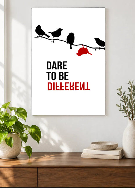 Dare to Be Different acrylic wall art displayed above a wooden console with plants and books against a white wall.