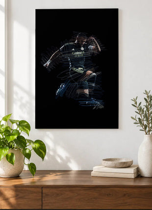 Dark Kit Celebration acrylic wall art displayed above a wooden console with plants and books against a white wall.