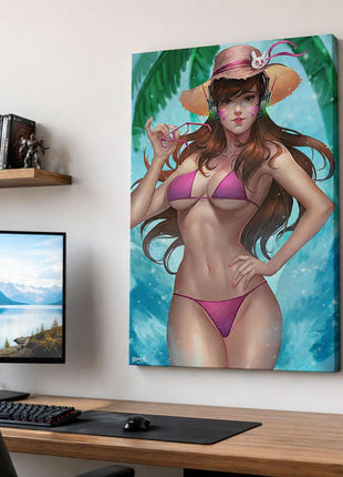 D.Va from Overwatch wearing a pink swimsuit, straw hat and headphones beside tropical water on canvas wall art beside a computer monitor and oak desk in a game room with white walls.