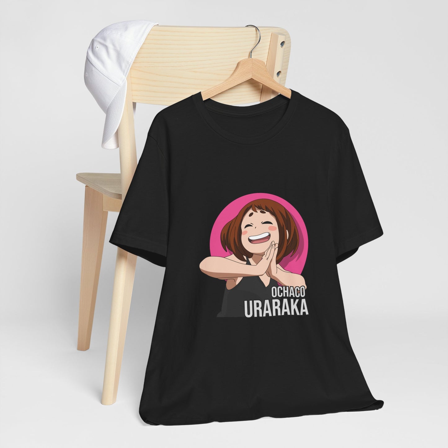 Alt: Gravity Hero Anime Shirt on black, hanging on chair with cap, lifestyle display by Snapping Turtle Gallery

