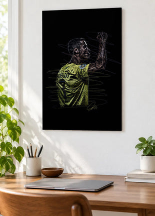 Green Shirt Raised Fist acrylic wall art displayed above a wooden desk with a laptop, plants and books against a white wall.