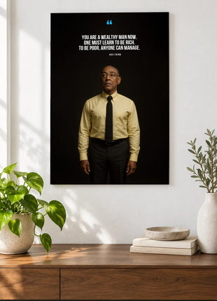 Gus Fring Learning to Be Rich acrylic wall art displayed above a wooden console with plants and books against a white wall.