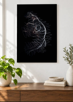 Hand in the Shadows acrylic wall art displayed above a wooden console with plants and books against a white wall.