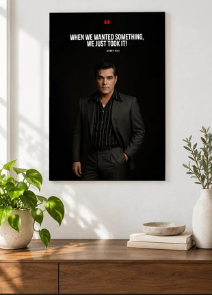 Henry Hill Taking What We Wanted acrylic wall art displayed above a wooden console with plants and books against a white wall.