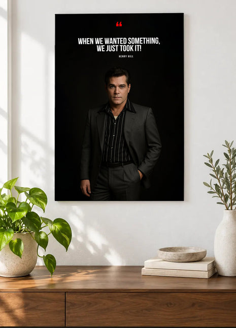 Henry Hill Taking What We Wanted acrylic wall art displayed above a wooden console with plants and books against a white wall.
