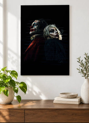 Joker and Harley Back to Back acrylic wall art displayed above a wooden console with plants and books against a white wall.