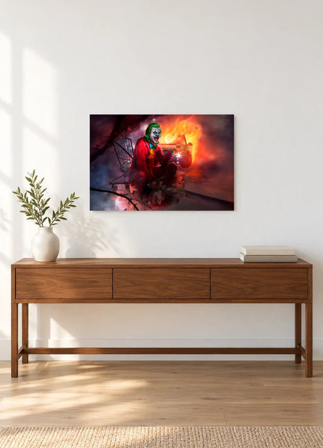 Joker Cart Full of Chaos acrylic wall art displayed above a wooden console with a leafy vase and stacked books against a white wall.