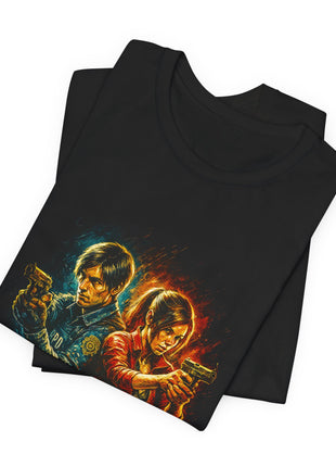 Folded black T-shirt close-up showing Leon and Claire’s faces, raised pistols and contrasting blue uniform and red jacket.