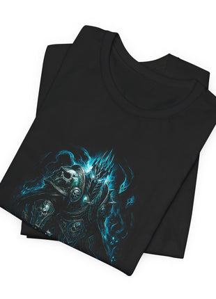 Folded black T-shirt close-up showing the Lich King’s tall helmet, pale hair and skull-decorated shoulder armor surrounded by blue wisps.