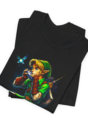 Folded black T-shirt detail showing Link’s face, blue ocarina, green cap and hovering winged light.