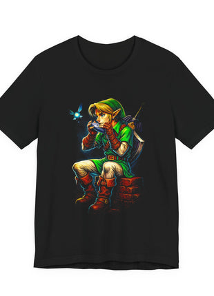 Black T-shirt front showing Link seated on brickwork playing a blue ocarina beside a glowing cyan fairy.