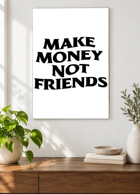 Make Money Not Friends acrylic wall art displayed above a wooden console with plants and books against a white wall.