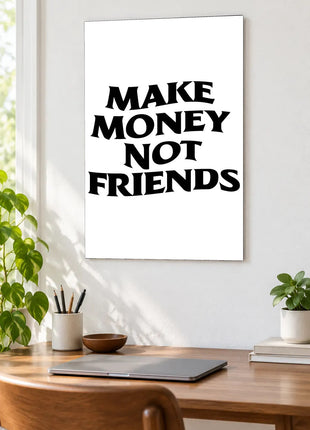 Make Money Not Friends acrylic wall art displayed above a wooden desk with a laptop, plants and books against a white wall.