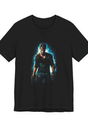 Front of black T-shirt showing Nathan Drake with a lowered pistol, blue shirt and brown shoulder straps against a cyan halo.