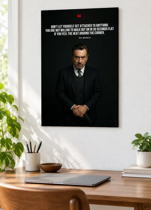 Neil McCauley Ready to Leave acrylic wall art displayed above a wooden desk with a laptop, plants and books against a white wall.