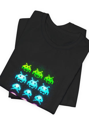 Folded black T-shirt detail showing the upper rows of green and cyan pixel aliens.