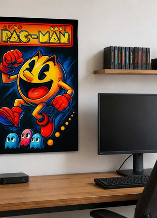 Pac-Man wearing red gloves and boots above three small ghosts, with arcade lettering across the top on metal wall art beside a computer monitor and oak desk in a game room with white walls.