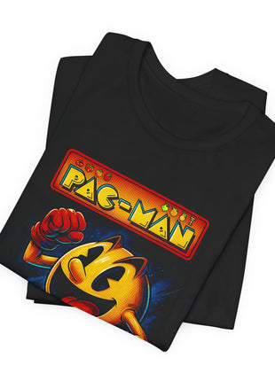Folded black T-shirt close-up of the Pac-Man heading, tiny fruit icons and Pac-Man’s raised red glove.