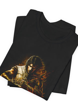 Folded black T-shirt detail of the split Prince portrait, contrasting shoulders, clasped hands and gold chain.
