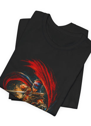 Folded black T-shirt close-up showing the Prince’s wrapped head covering, sword hand and bronze-toned clothing beneath a broad red arc.