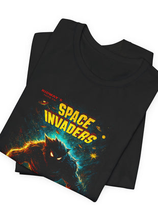 Folded black T-shirt detail showing the Space Invaders heading, small saucers and the cosmic monster’s head.