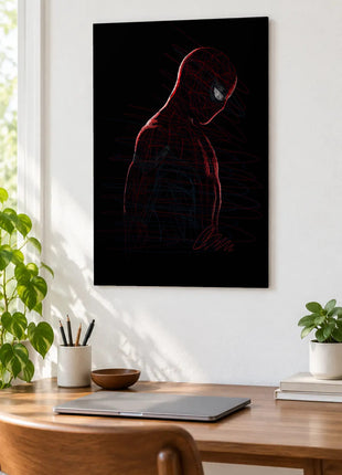 Spider-Man in Red Silence acrylic wall art displayed above a wooden desk with a laptop, plants and books against a white wall.