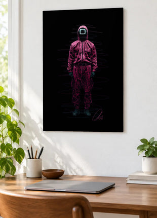 Square Mask in Pink acrylic wall art displayed above a wooden desk with a laptop, plants and books against a white wall.
