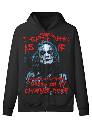Front of a black The Crow zip-up hoodie showing a blue-gray Eric Draven portrait and crow surrounded by red chamber door quote lettering.