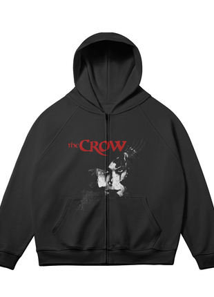 Alternate front view of the black The Crow Winged Shadow zip-up hoodie, with the pale Eric Draven face, dark crow motif and red title lettering and sleeves angled outward.