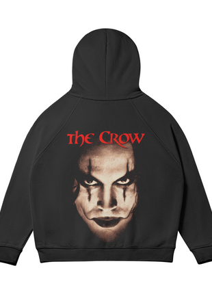 Rear view of the black The Crow Intense Gaze hoodie with the hood raised, showing the sepia Eric Draven face portrait and red title lettering across the back.