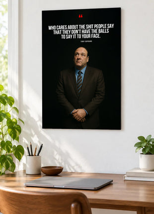 Tony Soprano Unspoken Opinions acrylic wall art displayed above a wooden desk with a laptop, plants and books against a white wall.