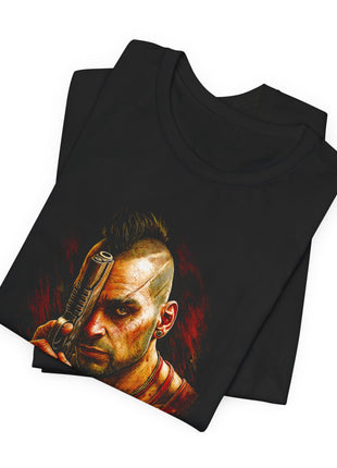 Folded black T-shirt close-up showing Vaas’s mohawk, facial scars and upright pistol in warm gold and red tones.