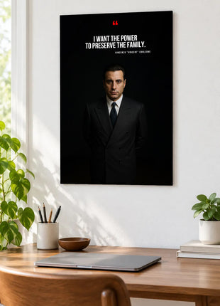 Vincent Corleone Family Resolve acrylic wall art displayed above a wooden desk with a laptop, plants and books against a white wall.