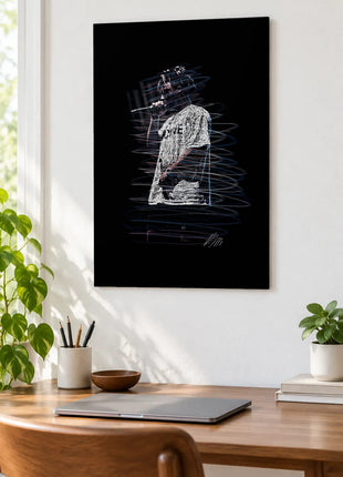 Voice in the Gray Shirt acrylic wall art displayed above a wooden desk with a laptop, plants and books against a white wall.