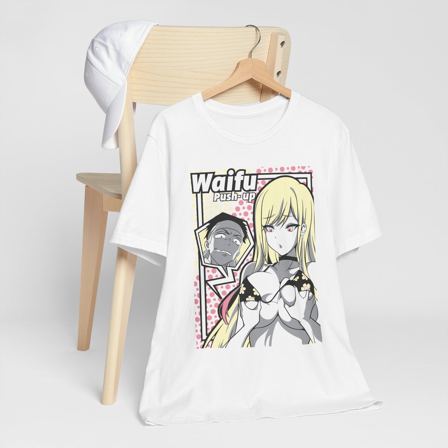 Alt: Waifu Pop Art Anime Shirt on white, hanging on chair with cap, lifestyle display by Snapping Turtle Gallery

