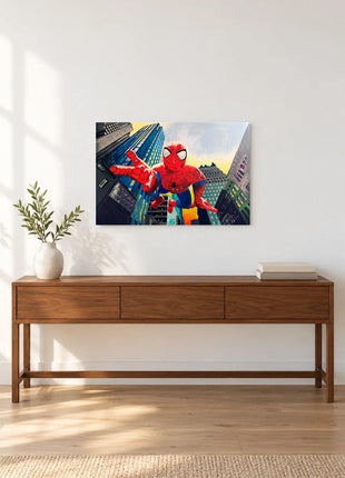 Spider-Man reaching toward the viewer between angled city buildings displayed above a console table in a room setting