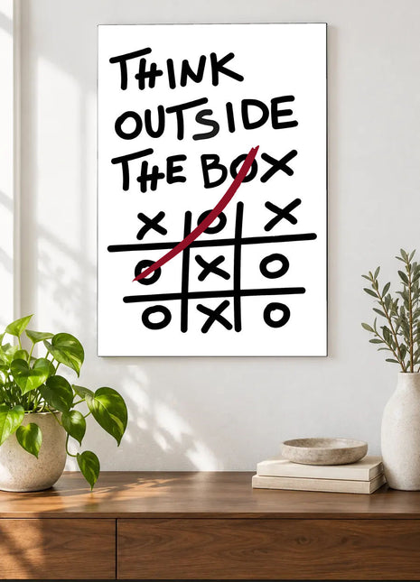 Win Outside the Lines acrylic wall art displayed above a wooden console with plants and books against a white wall.